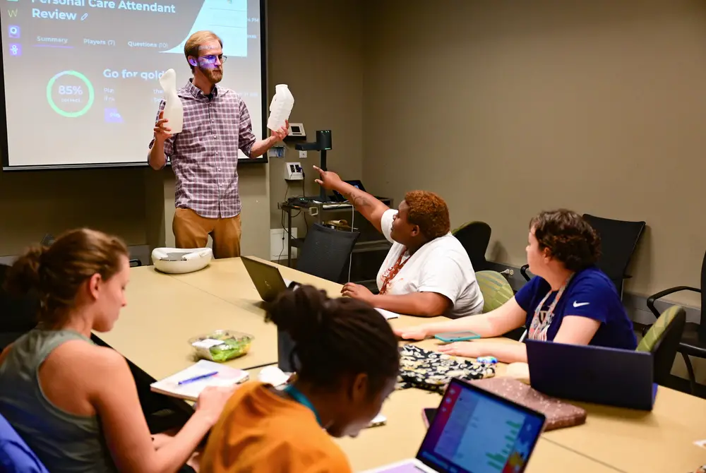 Joe Tate, a program director, teacher and disability advocate at E4Youth, teaches students with developmental disabilities about disability advocacy and becoming personal care attendants on Nov. 29, 2022, at the University of Texas at Austin. The students were part of the E4Texas program.