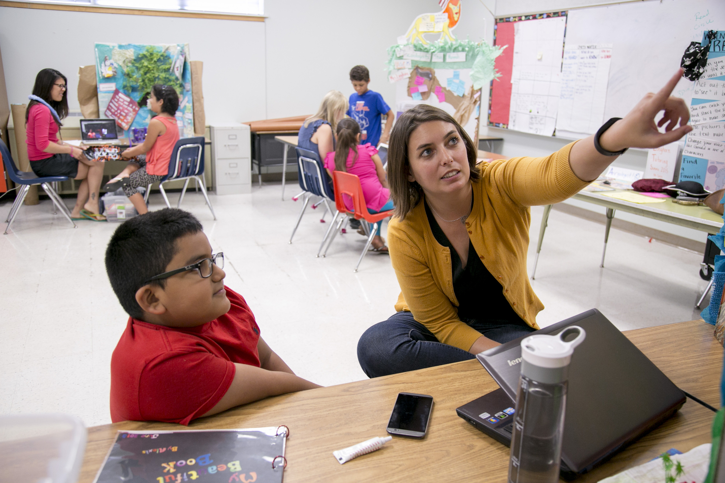 teacher showing a reading presentation to a student