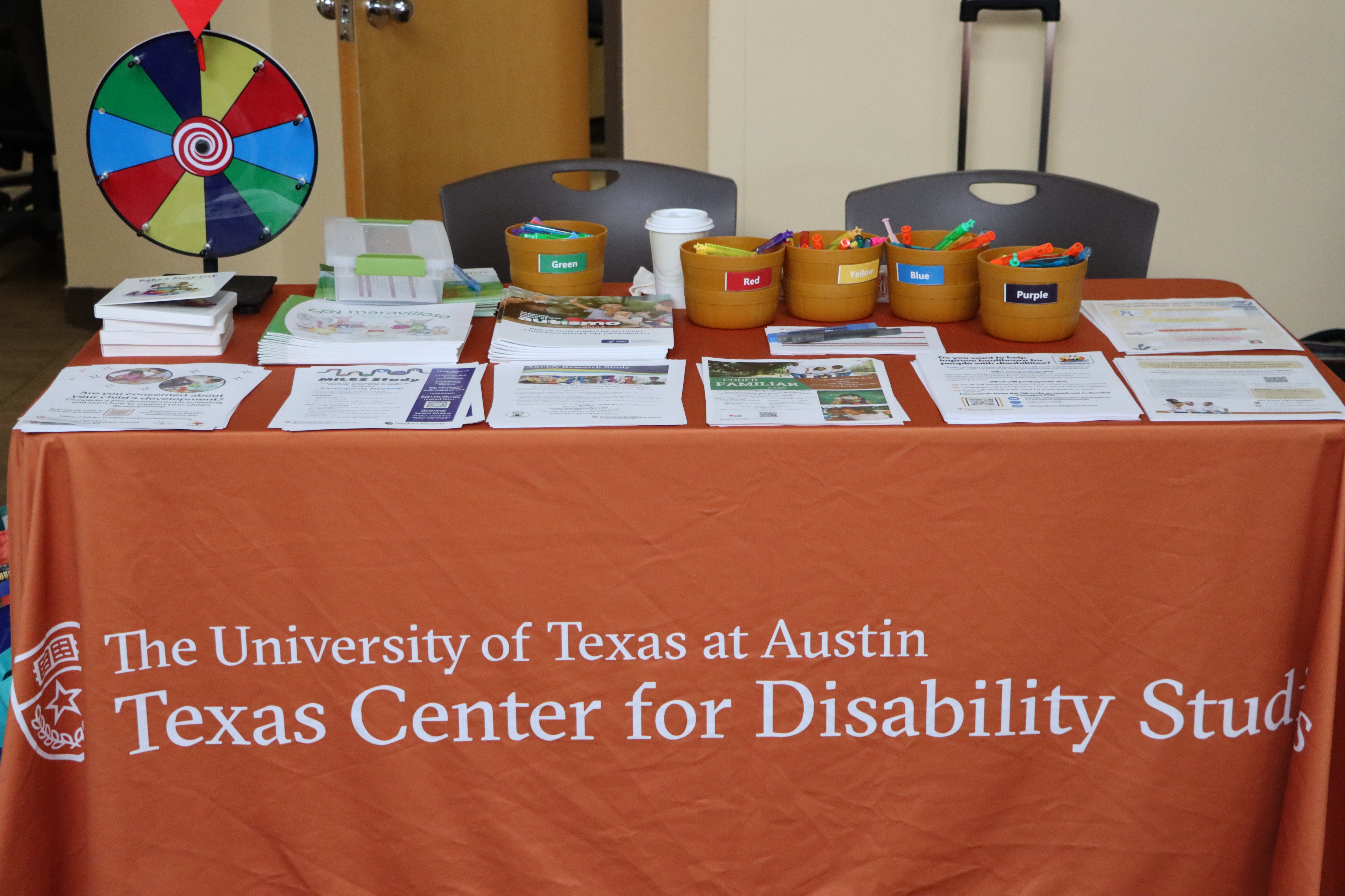 TCDS Vendor Table with our research flyers. UT burnt orange.