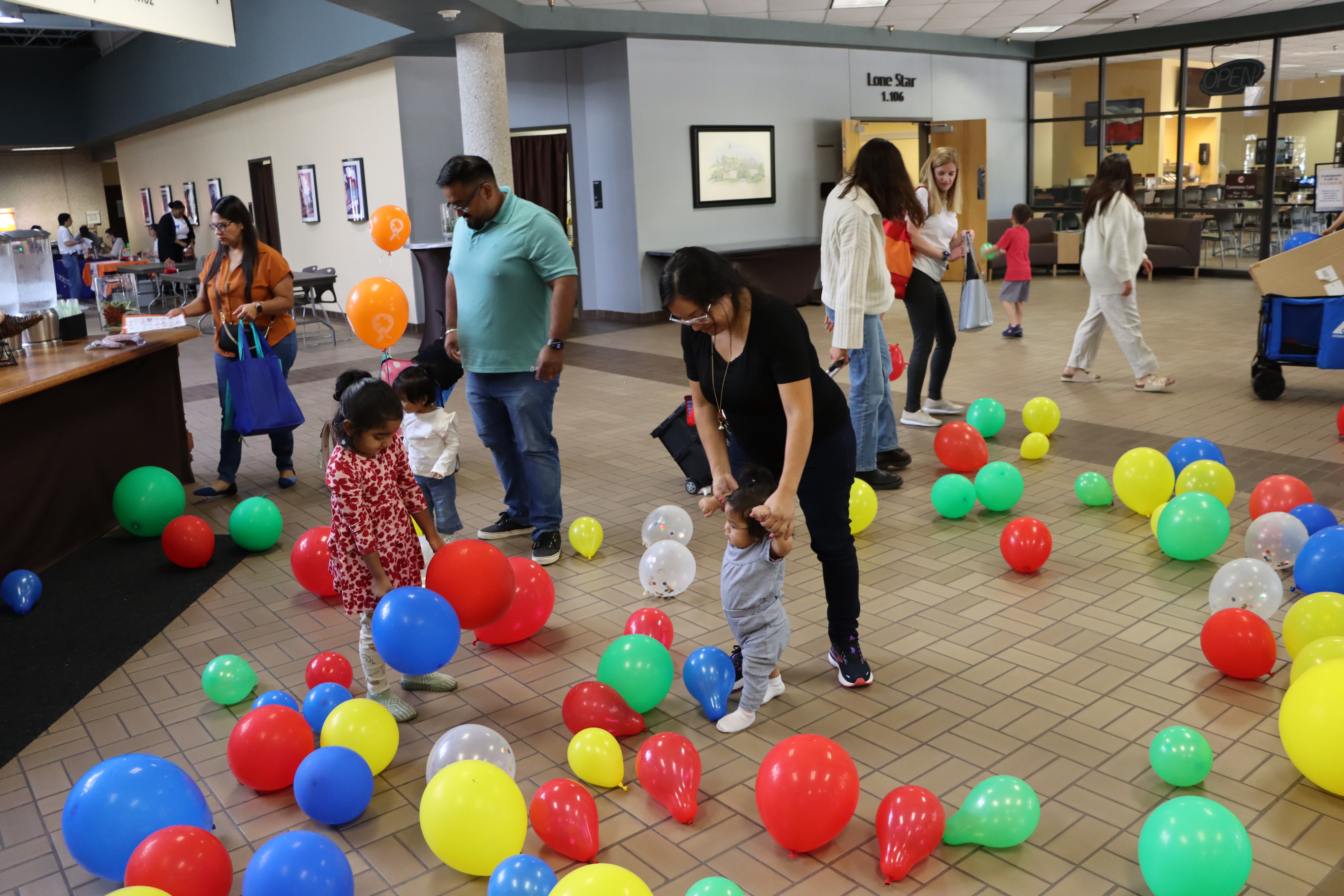 family attending our carnival screening event. they are picking up balloons together.