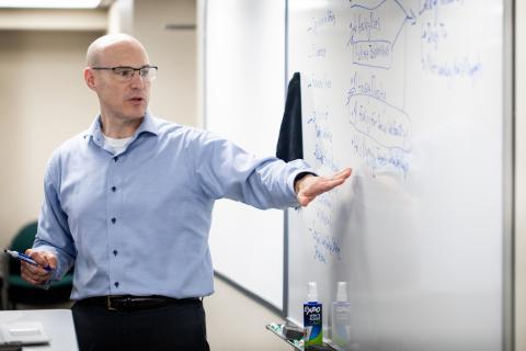 A professor teaching in a classroom at the School of Social Work.