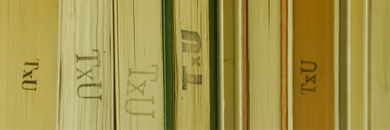 Image of a stack of books with the branding "TxU"