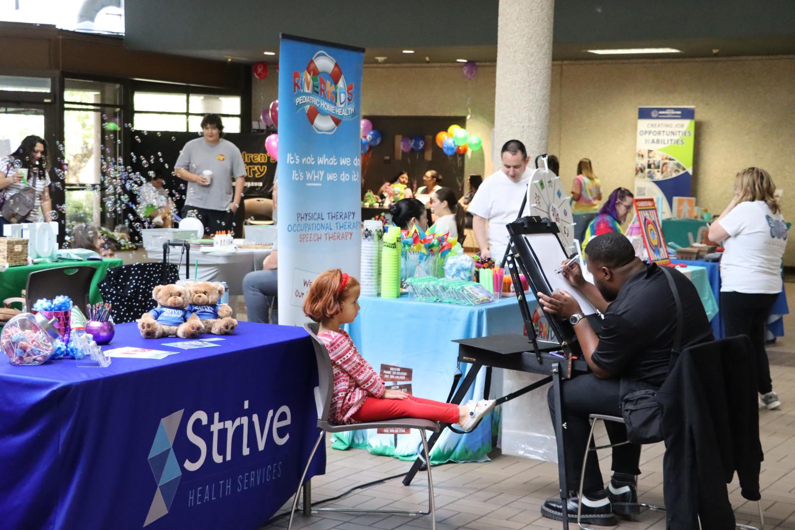 A row of community partner booths at the screening event. 