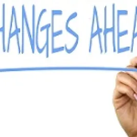 White dry erase / chalkboard with Changes Ahead written in blue ink