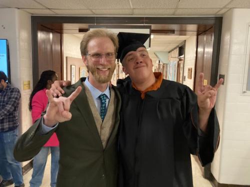 E4Texas Program Manager Joe Tate and E4Texas student Payton show off their "Hook'em" hand sign at E4 Graduation.