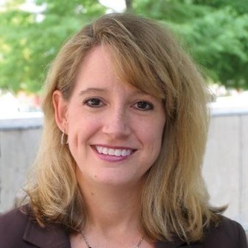 Beth Stalvey Description: Beth is a young woman with dark blonde hair. She wears a brown blouse with a necklace.