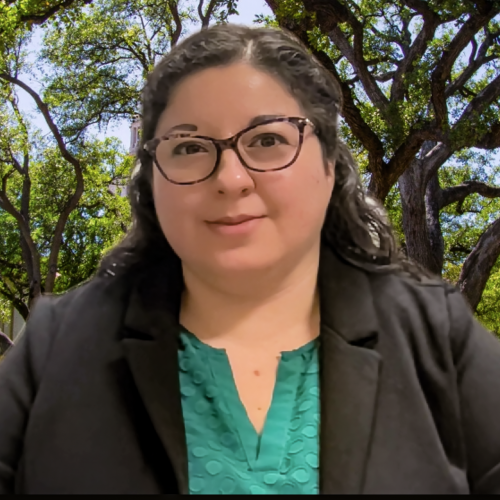 Sandra Vanegas has lightly curly dark hair and glasses. She wears a black blazer and an aqua blouse in front of a free-filled background.