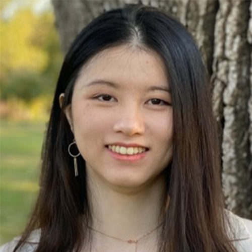 Profile Image of Minyu Zhang. Minyu has long black hair and a fair complexion. She wears a thin, chain necklace and dangling earrings. She stands posed in front of a tree. 