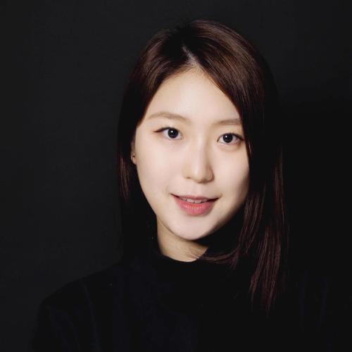 Jane is a young Asian woman with dark brown hair. She wears a black sweater in front of a black background.