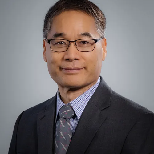 dan zhang; wearing a suit with glasses and short, dark hair and calm disposition