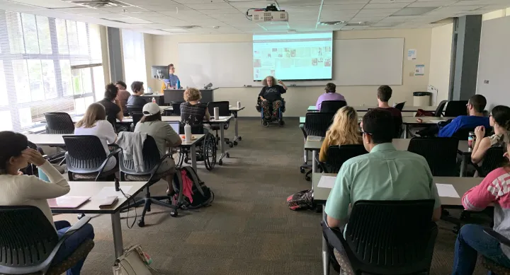 The November DASS Event with Stephanie Thomas at the head of a room discussing grassroots organizing and ADAPT. Students and staff watch her.