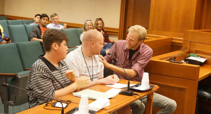 Photo of 3 people sitting at Austin Capitol presenting